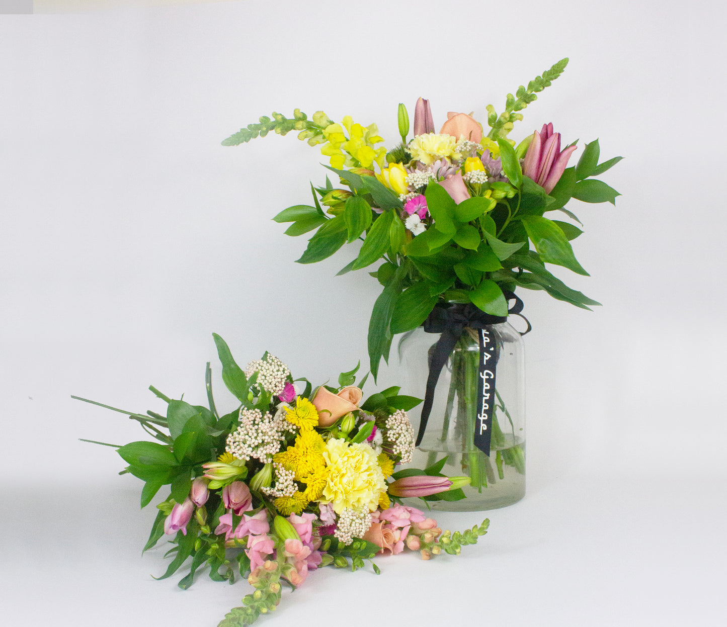 Two flower bouquets with a glass jar on a white background
