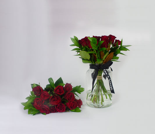 Romantic Bouquets of red roses in glass jars on a white background